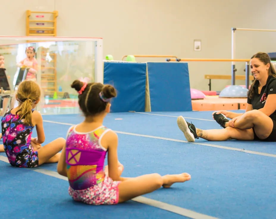 a person and two girls sitting on the floor