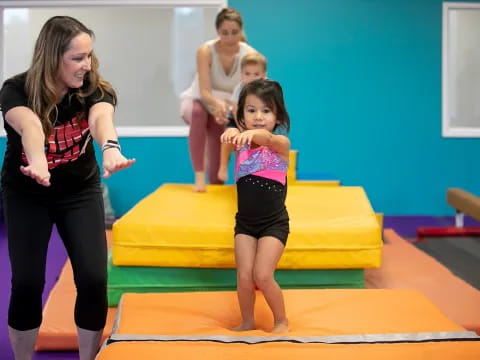 a woman and a girl in a gym