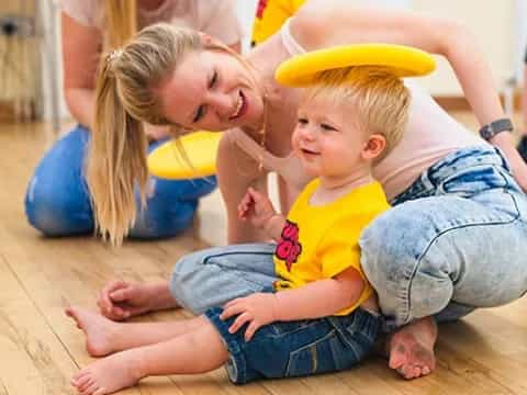 a person and a child playing with a yellow frisbee