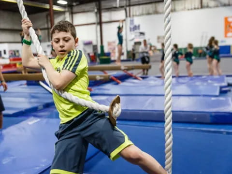 a boy jumping over a bar