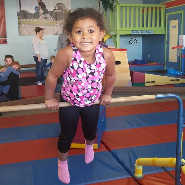 a girl standing on a blue mat