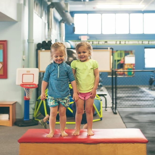 two children standing on a mat