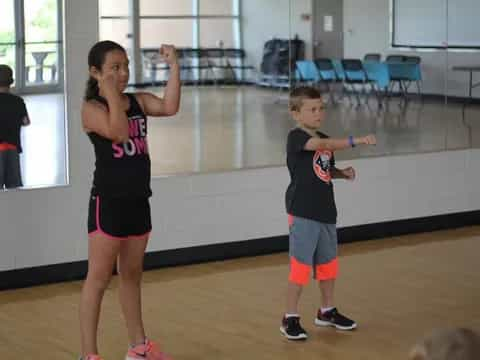 a woman and a boy playing basketball