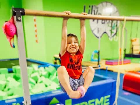 a boy jumping over a bar