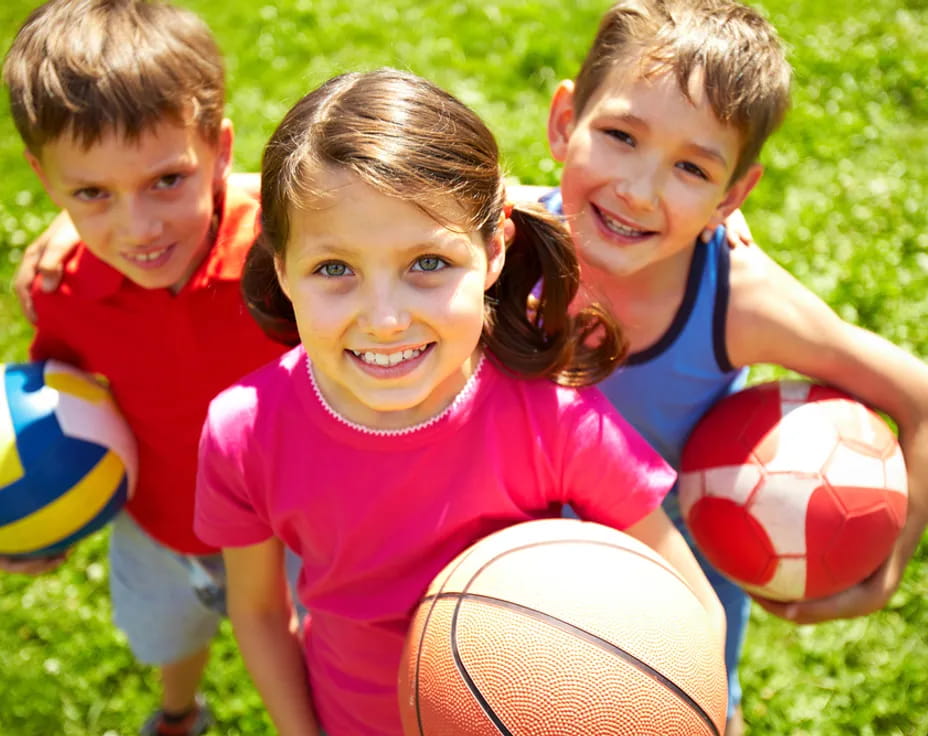 a group of kids holding balls