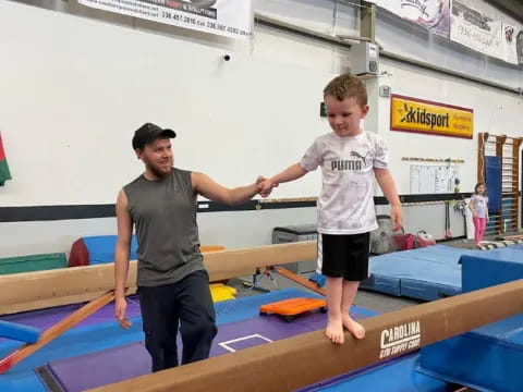 a person and a boy playing on a mat in a room