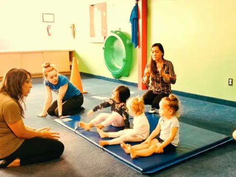 a group of women and children sitting on the floor