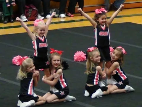 a group of girls in cheerleader uniforms on a field