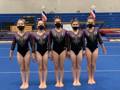 a group of women wearing leotards and posing for a photo