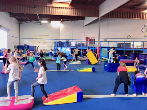 a group of people playing on a mat in a gym