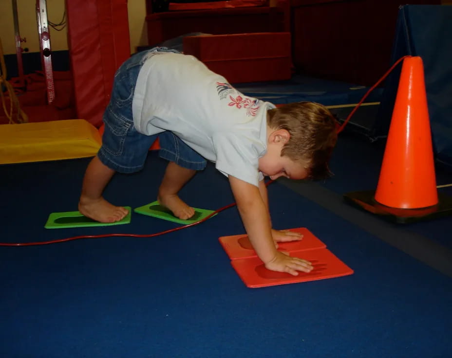 a boy doing a push up on a mat