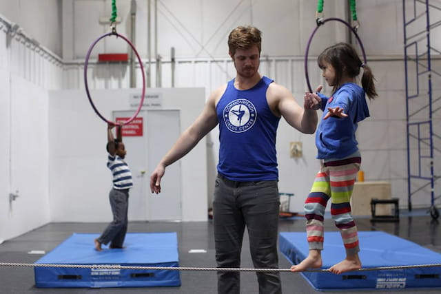 a person and a couple of children playing ping pong