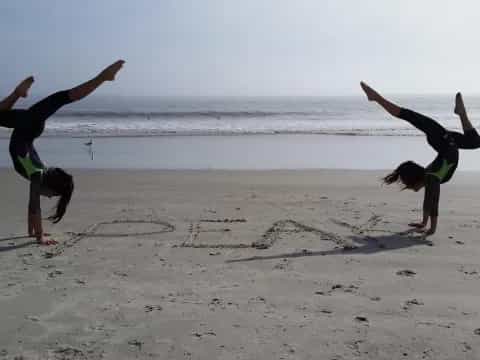 a group of people doing yoga on a beach