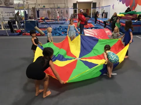 a group of children playing on a large colorful tent