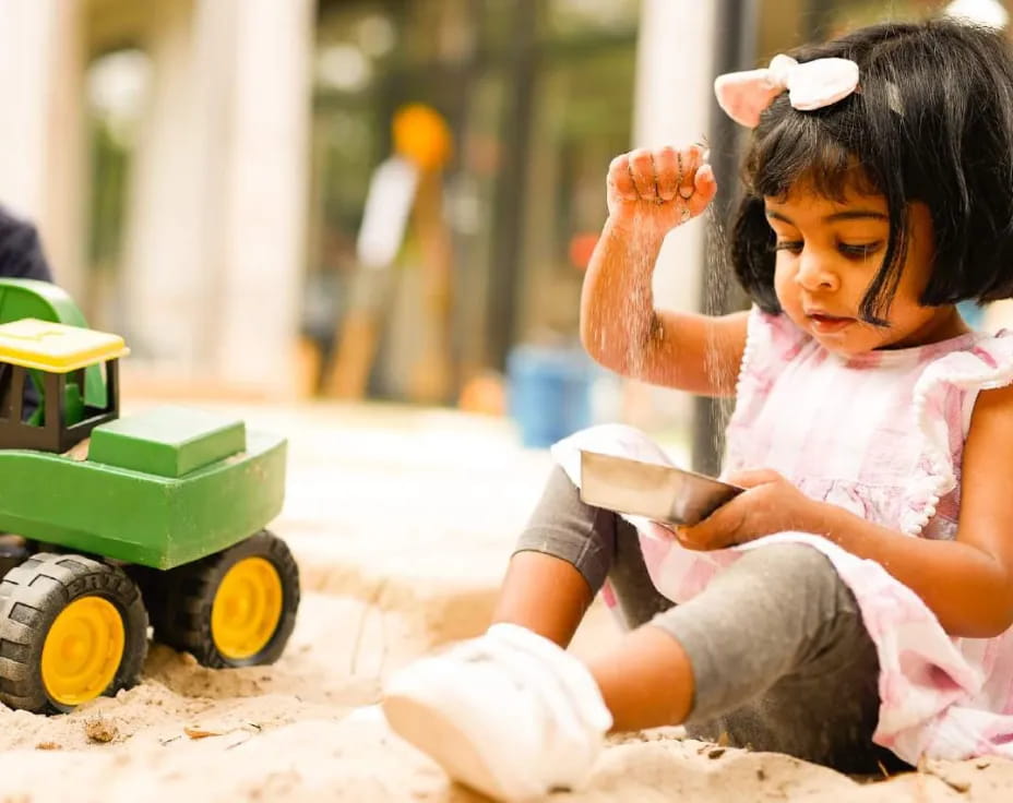 a little girl playing in the sand