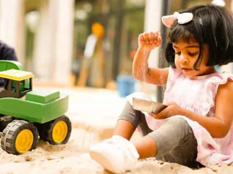 a little girl playing in the sand
