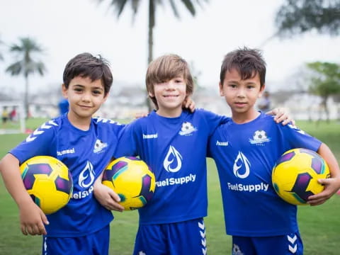 a group of boys holding football balls