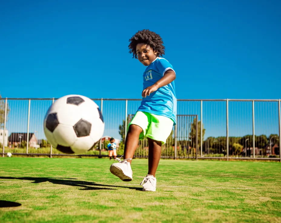 a kid kicking a football ball