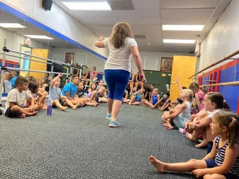 a woman standing on her hands in front of a group of people