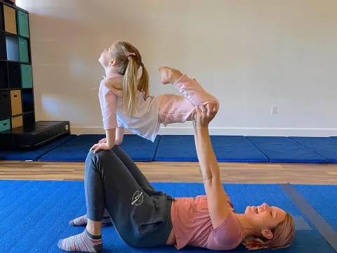 a person doing a handstand with a child on the floor