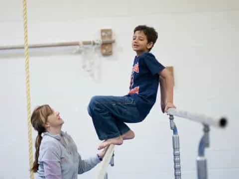 a boy jumping on a bar