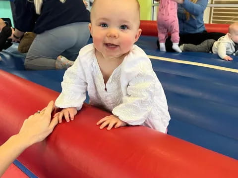 a baby sitting on a red slide