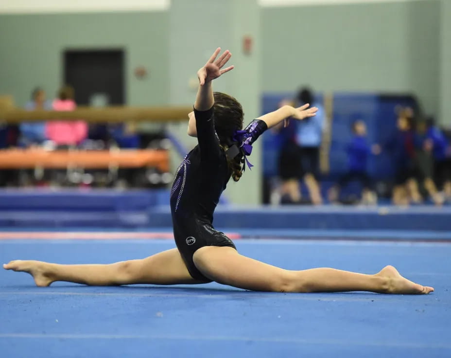 a woman in a leotard doing a gymnastics move