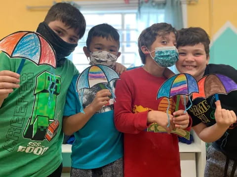 a group of kids holding paint brushes