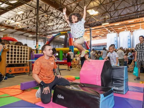 a man holding a woman on a mat in a gym