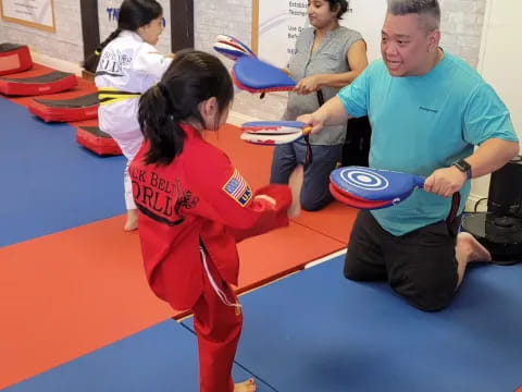 a person and a girl in a karate uniform