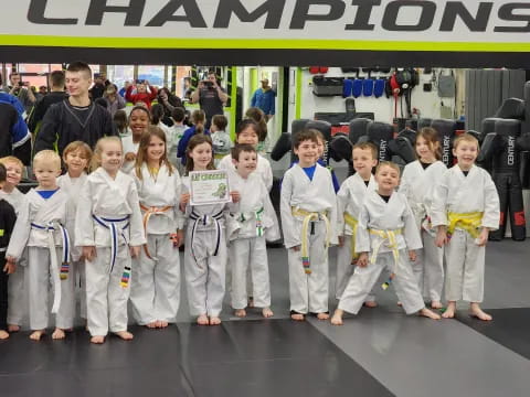 a group of children in matching white karate uniforms