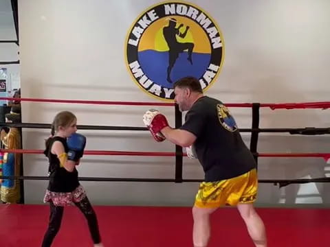 a person and a girl in a boxing ring