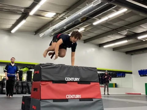 a person jumping over a stack of boxes