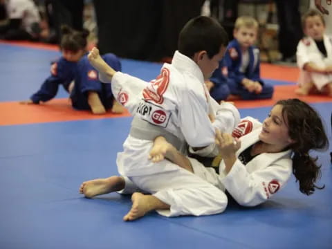 a man and a woman in karate uniforms kneeling on the ground