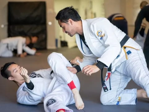 a man in a karate uniform kicking another man in the face