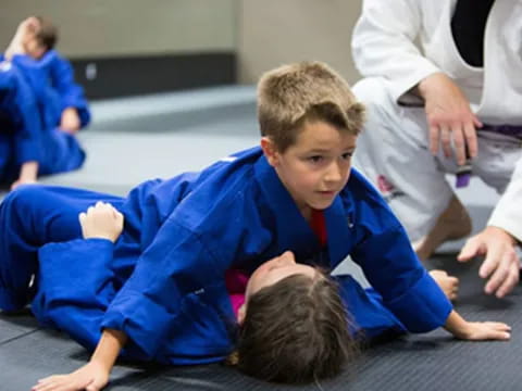 a boy lying on the floor with other people around him