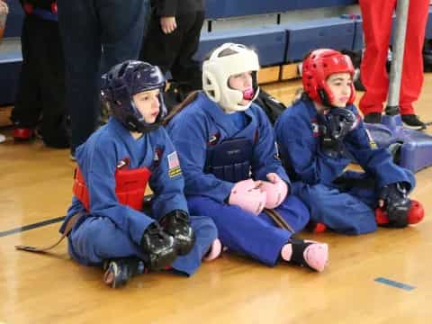 a group of kids wearing helmets and sitting on the floor