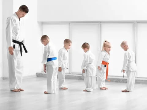 a group of people in white karate uniforms