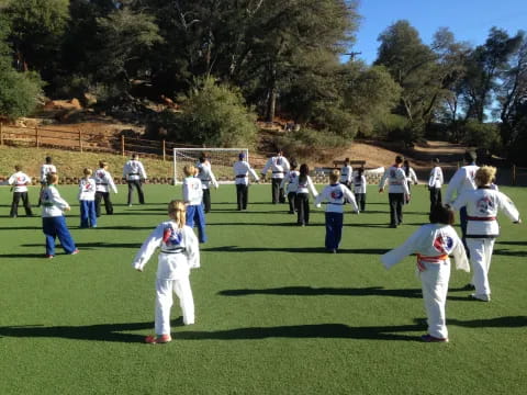 a group of people in white karate uniforms on a field