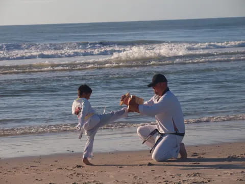 a man and a boy playing baseball on a beach