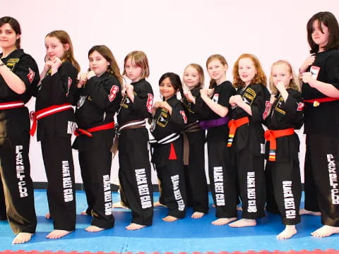 a group of women in black and red karate uniforms