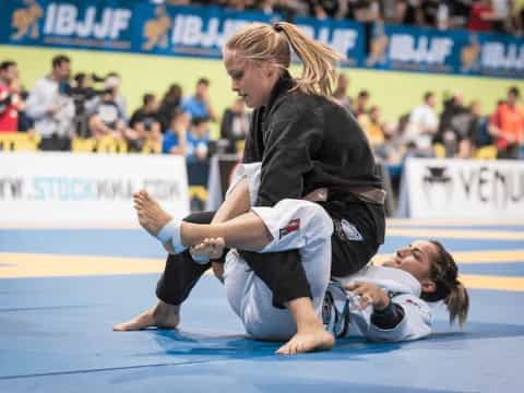 a man kneeling on another woman's back on a mat