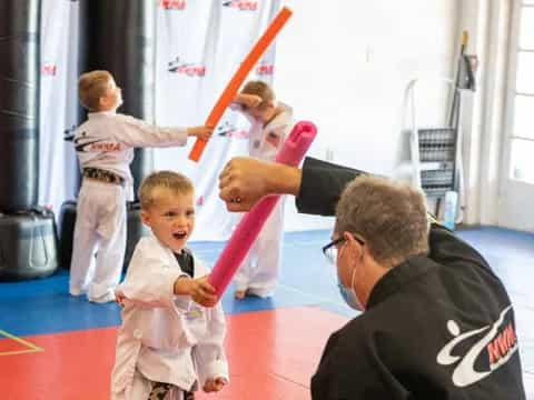 a person and a child playing with a toy sword