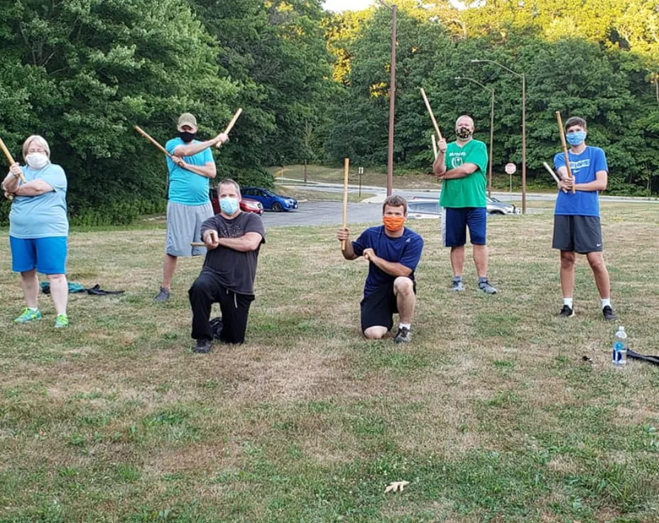 a group of people holding sticks