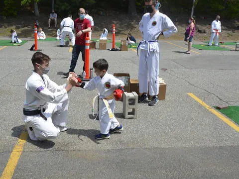 a group of people in white karate uniforms holding swords