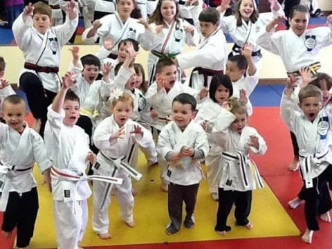 a group of children in white karate uniforms