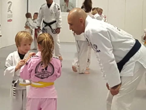 a person and a couple children in karate uniforms