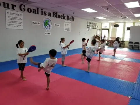 a group of kids playing frisbee in a gym