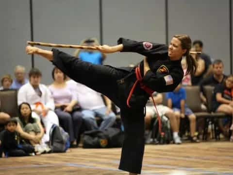 a person doing a handstand on a court with a crowd watching