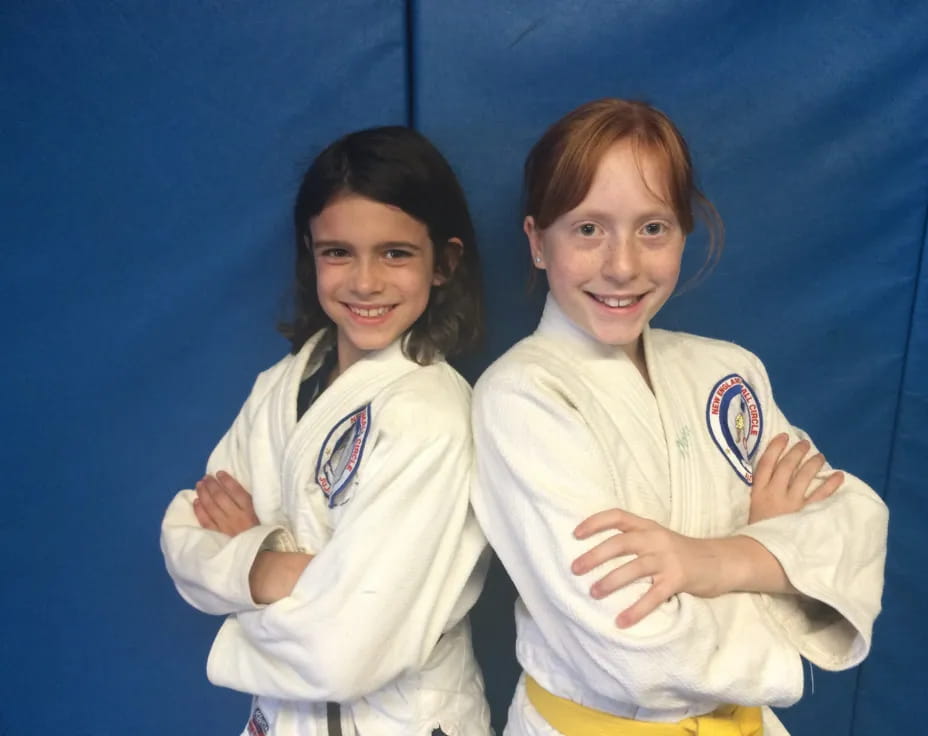 two girls in karate uniforms